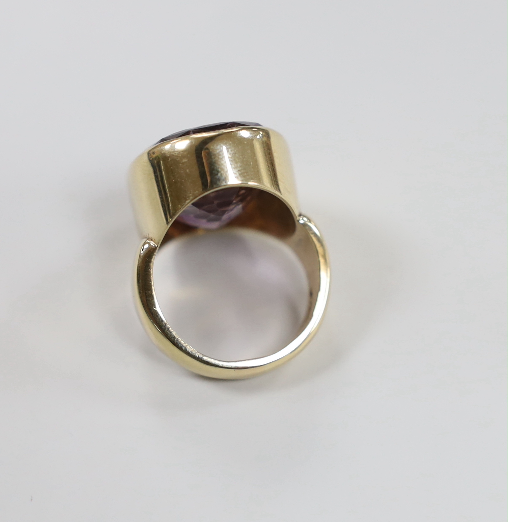A modern 9ct yellow gold and amethyst intaglio set oval ring, carved with the head of a gentleman to sinister, size O, gross weight 18.2 grams.